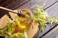 Honey in jar with linden flowers and honey dipper on wooden background Royalty Free Stock Photo