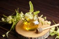 Honey in jar with linden flowers and honey dipper on wooden background Royalty Free Stock Photo
