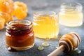 Honey in jar with wooden honey dipper, liquid honey