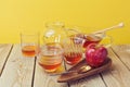 Honey jars and apple on wooden table.