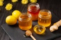 Honey in jars, dipper, lemon, ginger on a dark background Royalty Free Stock Photo