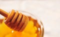 Honey macro with wooden honey dipper in the glass jar