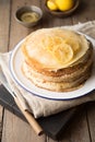 Honey or maple syrup pouring over crepes. Closeup view of stack of thin pancakes, blini