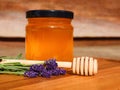 Glass jar of liquid honey with lavender and wooden honey spoon. Royalty Free Stock Photo