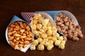 Honey peanuts with caramel popcorn and closeup of honey sesame seed almonds in paper cones