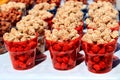 Caramelised eanuts with sesame seeds in red transparent cups. Royalty Free Stock Photo