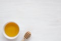 Honey in a plate and a honey stick on a light background. Copy space for text. Royalty Free Stock Photo