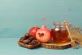 Honey, pomegranate, apple and dates on wooden board. Jewish New Year Rosh hashana