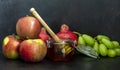 Honey, pomegranate, and apples on the black table. Jewish New Year Rosh Hashanah postcard