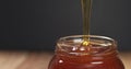 Honey pour with spoon in glass jar