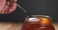 Honey pour with spoon in glass jar