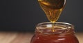 Honey pour with spoon in glass jar