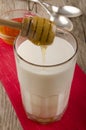 Honey is poured into a glass of warm milk Royalty Free Stock Photo