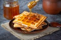 Honey pouring on a fresh waffles. Breakfast with Belgian waffles