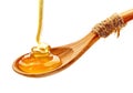 Honey pouring into wooden spoon