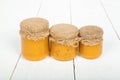 Honey with sea buckthorn in glass jars on white wooden boards