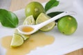 Honey on Spoon with Green Lime on Plate Royalty Free Stock Photo