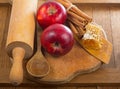 Honey spoon, jar of honey, apples and cinnamon on a wooden background in a rustic style Royalty Free Stock Photo