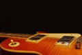 Honey sunburst vintage electric blues guitar closeup on the black background, with plenty of copy space. Royalty Free Stock Photo