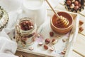 Honey in the wooden bowl, hazelnuts and jar with milk on the wooden tray Royalty Free Stock Photo