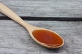 Honey in wooden spoon has a sweet taste on wooden table background.