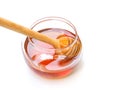 Honey with wooden honey stick in clear glass jar isolated on white background