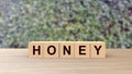 Honey word Wooden cubes on table over background leaves green HD, mock up, template, love for one`s partner, good friends, Sweet