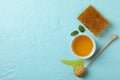 Honeycomb, dipper and bowl honey on blue background