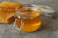 Honeycombs and glass jar honey on gray background Royalty Free Stock Photo