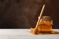 Honeycombs jar with honey and dipper on wooden background Royalty Free Stock Photo