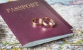 Honeymoon concept. Wedding rings with passports on the map