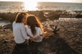 Honeymoon couple relaxing on romantic sunset, enjoying evening , relaxing on tropical summer vacation on the rocky beach Royalty Free Stock Photo