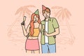 Honeymoon happy couple drinking champagne, standing on beach of sunny resort, wearing birthday caps Royalty Free Stock Photo