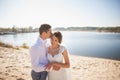 Honeymoon of just married wedding couple. happy bride, groom standing on beach, kissing, smiling, laughing, having fun on beach Royalty Free Stock Photo