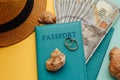 Honeymoon traveling concept. Passports with money, tourist hat and shells close-up on a blue yellow background