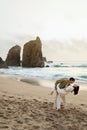 Honeymoon trip. Happy young couple dancing on beach near sea, having fun, enjoying date near ocean shore, vertical shot Royalty Free Stock Photo