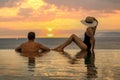 Honeymoon vacation - couple enjoying romantic sunset in infinity pool at luxury resort Royalty Free Stock Photo