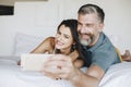 Honeymooners taking a selfie in bed Royalty Free Stock Photo