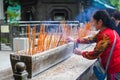 HONG KONG APRIL 2018 - chinese lady is praying in Wong Tai Sin temple. woman lights incense in the temple