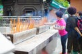 HONG KONG APRIL 2018 - chinese lady is praying in Wong Tai Sin temple. woman lights incense in the temple