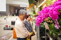 HONG KONG - APRIL 2018: elderly asian man choose various beautyful pink orchid in pots in street flower market