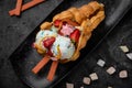 Hong Kong or bubble waffle with ice cream, fruits and colorful candies