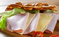 Hong Kong bubble waffles sandwich with ham, cheese and vegetables on wooden table