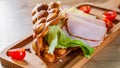 Hong Kong bubble waffles sandwich with ham, cheese and vegetables on wooden table Royalty Free Stock Photo