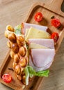 Hong Kong bubble waffles sandwich with ham, cheese and vegetables on wooden table Royalty Free Stock Photo