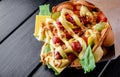 Hong Kong bubble waffles sandwich with sausage, cheese and vegetables on black wooden table Royalty Free Stock Photo