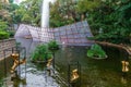 Fountain with splash protection in the pond in Kowloon Park on rainy day. Natural landmark in