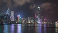 Hong Kong city skyline at night over Victoria Harbor with cloudy sky and urban skyscrapers timelapse hyperlapse. Royalty Free Stock Photo