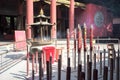 Hong Kong : November 20, 2019 - Closeup group of incenses put in the brass ashtray with smoke in the air at Wong Ta Sin temple