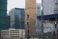 Unidentified workers are scaffolding on the site in the city surrounding by skyscrapers in Central Royalty Free Stock Photo